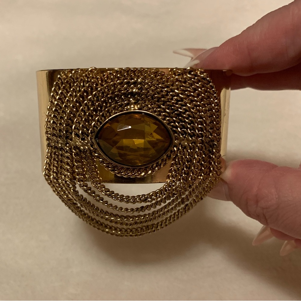 Gold cuff with attached chains and amber large stone at center- costume jewelry
